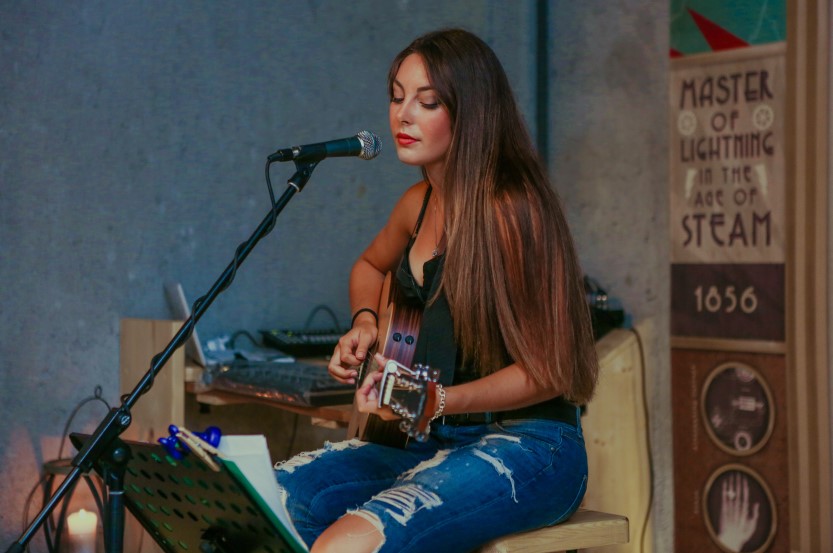 woman playing acoustic guitar singing