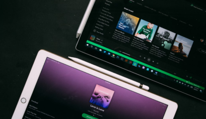 Two tablets displaying Spotify, one showing a playlist and the other the browse section.
