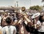 Argentina supporters playing brass instruments and singing during a football celebration, highlighting the role of music in football culture.