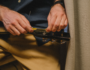 Musician replacing guitar strings while tuning an acoustic guitar.