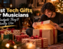 Musician opening a Christmas gift surrounded by presents and guitars, featuring the best tech gifts for musicians.